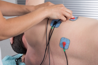 Orthopaedic treatment electrostimulator. Electrodes of the girl in neck.